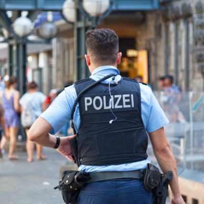 Police officer pictured from the back. On the back of his west the word "Polizei".