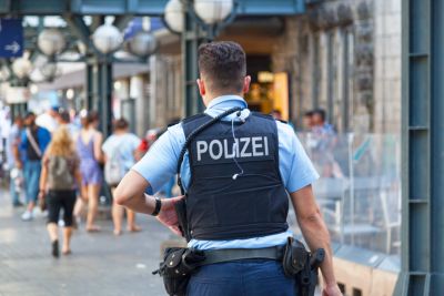 Police officer pictured from the back. On the back of his west the word "Polizei".